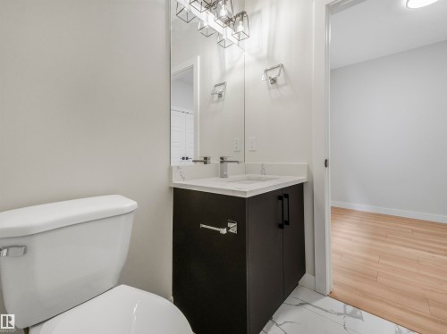 Modern vanity with a vessel sink and chrome faucet, under-cabinet storage, and an illuminated mirror - 11 Dalquist Bay, Leduc, AB 