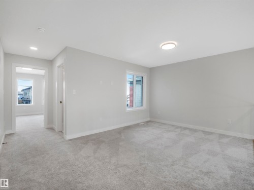 Spacious room with plush gray carpeting, recessed lighting, and a flush-mount ceiling light - 11 Dalquist Bay, Leduc, AB 