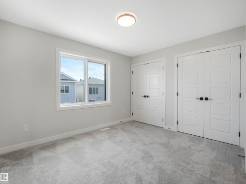 Soft gray carpeting, white walls, and a contemporary flush-mount ceiling light - 11 Dalquist Bay, Leduc, AB 