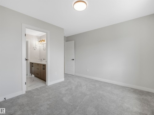Light gray carpeting, white walls, and a contemporary ceiling light fixture - 11 Dalquist Bay, Leduc, AB 
