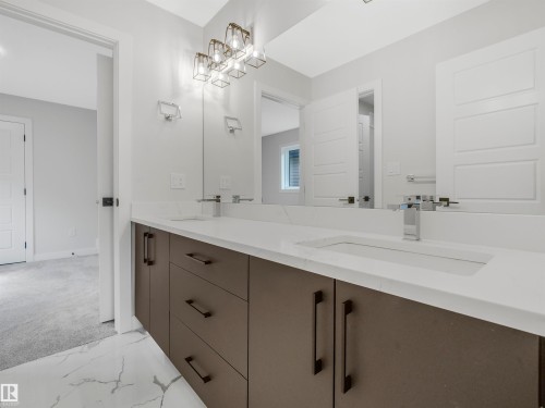 Dual sink vanity with quartz countertops, integrated rectangular sinks, and matte black hardware - 11 Dalquist Bay, Leduc, AB 