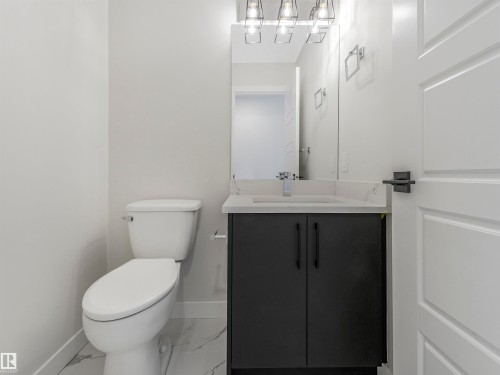 Modern vanity with dark cabinetry, integrated rectangular sink, and light-toned countertop - 11 Dalquist Bay, Leduc, AB 