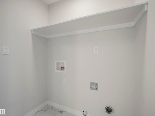 Built-in shelving, laundry hookups, wall outlets, and light-toned walls - 11 Dalquist Bay, Leduc, AB 