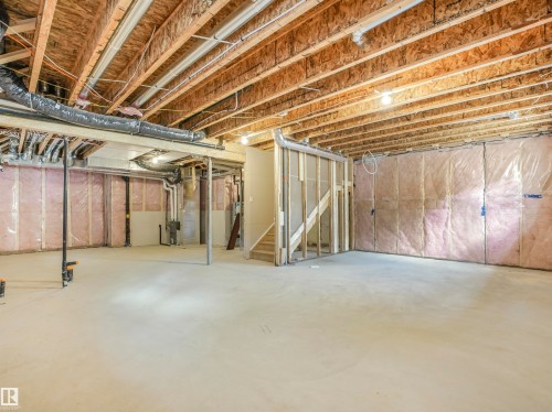 Unfinished basement with exposed ceiling joists, concrete flooring, and framed walls with insulation - 11 Dalquist Bay, Leduc, AB 