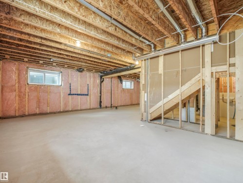 Unfinished basement featuring exposed wood framing, concrete flooring, two windows, and visible ductwork - 11 Dalquist Bay, Leduc, AB 