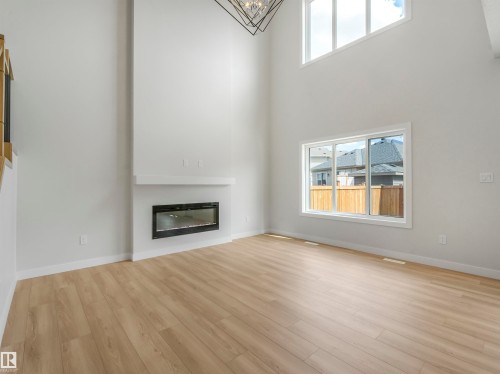 Vaulted ceilings, wood-finish flooring, and a modern fireplace with a white mantel - 11 Dalquist Bay, Leduc, AB 