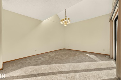 Vaulted ceiling with an angular design, suspended chandelier, and light-colored carpeting - #23 500 Lessard Dr Nw, Edmonton, AB 