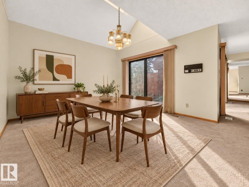 Vaulted ceiling, contemporary chandelier, sliding glass door, and a built-in buffet niche - #23 500 Lessard Dr Nw, Edmonton, AB 