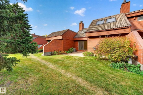 Terracotta tiled roof with skylights, wood siding, and a brick exterior accent - #23 500 Lessard Dr Nw, Edmonton, AB 