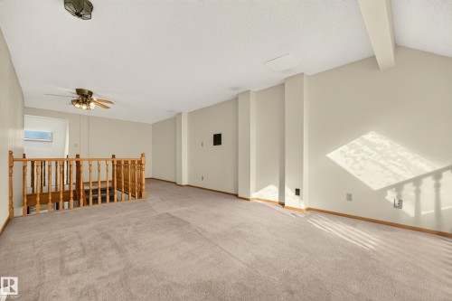 Carpeted flooring, vaulted ceiling, wood-finish railing, ceiling fan, and recessed lighting - #23 500 Lessard Dr Nw, Edmonton, AB 