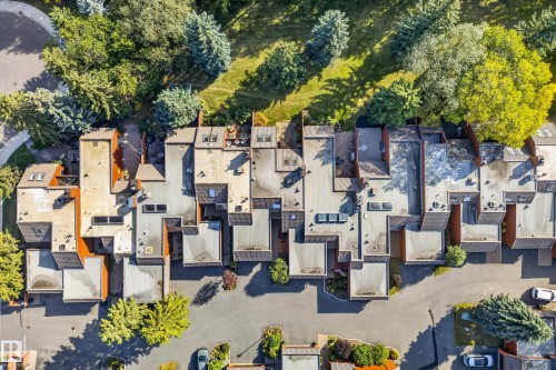 Townhome community featuring a paved street, extensive green spaces, and mature trees - #23 500 Lessard Dr Nw, Edmonton, AB 