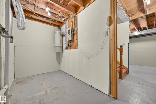 Unfinished basement space with exposed ceiling joists, partially finished walls, concrete flooring, and visible utility systems - #23 500 Lessard Dr Nw, Edmonton, AB 