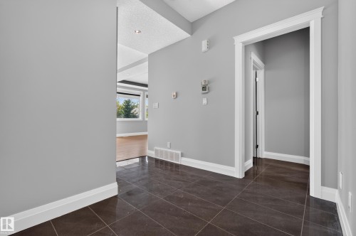 Dark tile flooring, light gray wall paint, white trim, recessed ceiling lighting, and a window with outdoor scenery - 11167 62 Avenue Nw, Edmonton, AB 