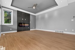 Wood-finish flooring, recessed lighting, and a tray ceiling with a mounted fan - 
