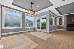 Wood-finish flooring, recessed lighting, contemporary chandelier, gas fireplace, and sliding glass doors to exterior - 
