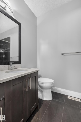 Dark wood-finish vanity with chrome hardware, an integrated sink, and a light-toned countertop - 11167 62 Avenue Nw, Edmonton, AB 