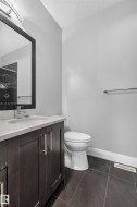 Dark wood-finish vanity with chrome hardware, an integrated sink, and a light-toned countertop - 