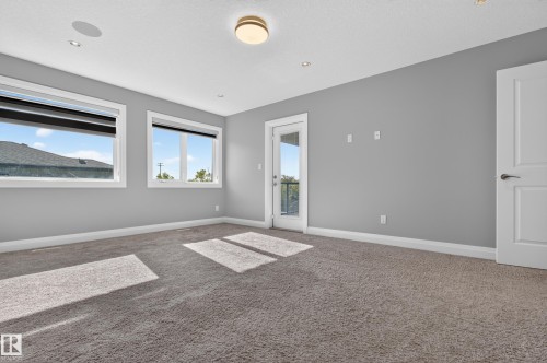 Spacious room with gray wall paint, light gray carpeting, and white trim - 11167 62 Avenue Nw, Edmonton, AB 