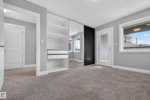 Built-in closet system with mirrored doors, white interior shelving, and integrated drawers - 11167 62 Avenue Nw, Edmonton, AB 