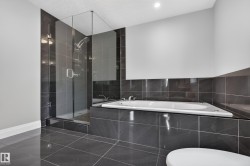 Glass-enclosed shower with a rainfall showerhead, and a built-in tub with tile surround - 