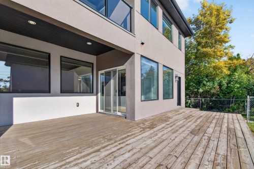 Expansive exterior deck, light stucco facade, large black-framed windows, and sliding glass door - 11167 62 Avenue Nw, Edmonton, AB 