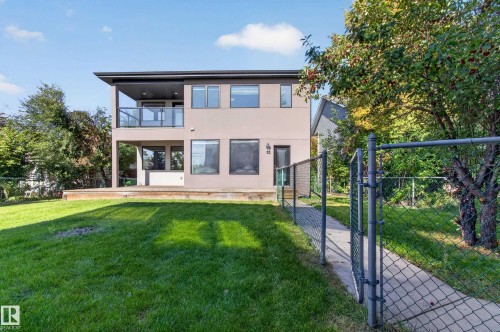 Expansive backyard with a manicured lawn, full-light windows, and a raised wood-finish deck - 11167 62 Avenue Nw, Edmonton, AB 