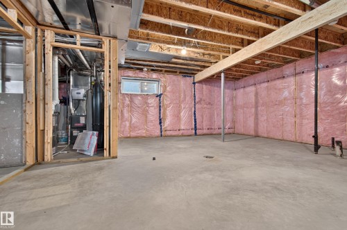 Unfinished basement with concrete flooring, exposed wood framing, and pink insulation - 11167 62 Avenue Nw, Edmonton, AB 