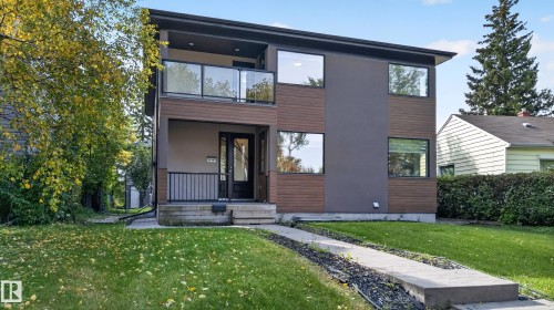 Contemporary exterior featuring a two-story design, a balcony with glass railings, large windows, and a combination of smooth and textured siding - 11167 62 Avenue Nw, Edmonton, AB 