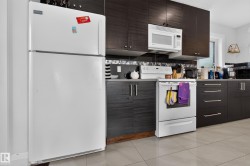 Kitchen featuring dark wood-finish cabinetry, tile flooring, and a glass tile backsplash - 