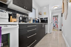 White range with overhead ventilation, dark wood-finish cabinetry, and a tile backsplash - 