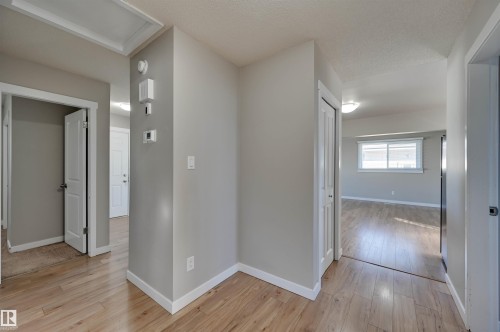 Wood-finish flooring throughout, neutral wall tones, and white trim - 13815 88 Street Nw, Edmonton, AB 