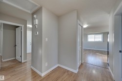 Wood-finish flooring throughout, neutral wall tones, and white trim - 