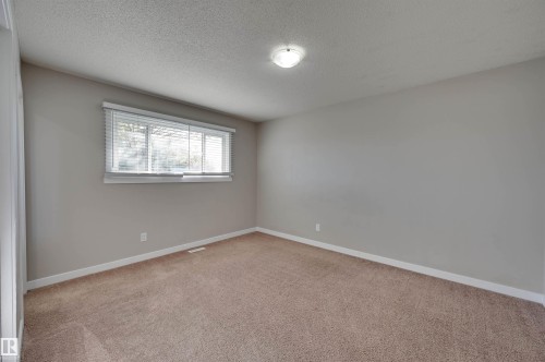 Neutral wall paint and carpeting, modern overhead lighting, and window with horizontal blinds - 13815 88 Street Nw, Edmonton, AB 