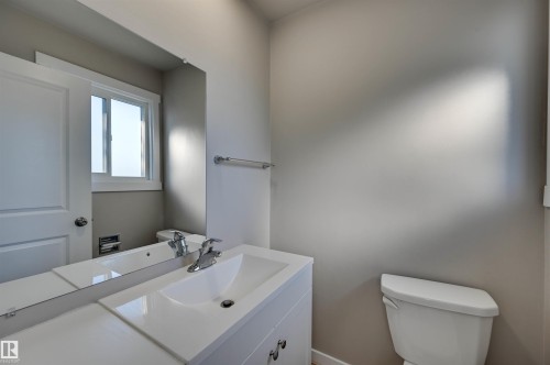 White vanity with an integrated sink, chrome faucet, and expansive mirror - 13815 88 Street Nw, Edmonton, AB 