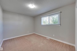 Neutral wall tones, carpeted flooring, a single window with blinds, and an overhead flush-mount light fixture - 