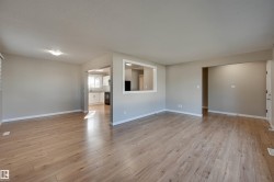 Expansive room featuring wood-finish flooring, neutral wall tones, and recessed lighting - 