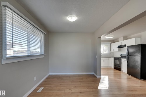 Bright interior with wood-finish flooring, a large window with blinds, and recessed lighting - 13815 88 Street Nw, Edmonton, AB 