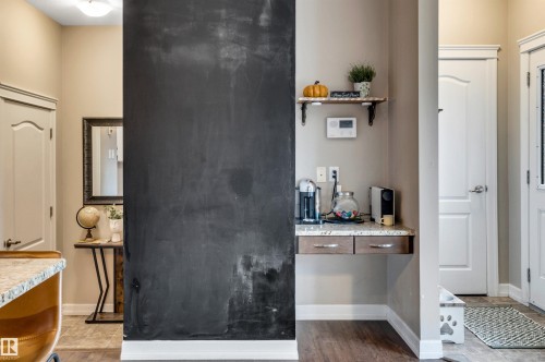 Built-in chalkboard wall, wood-finish flooring, built-in floating desk with stone-finish countertop, two built-in drawers, and wall-mounted shelving - 337 Southfork Drive, Leduc, AB 