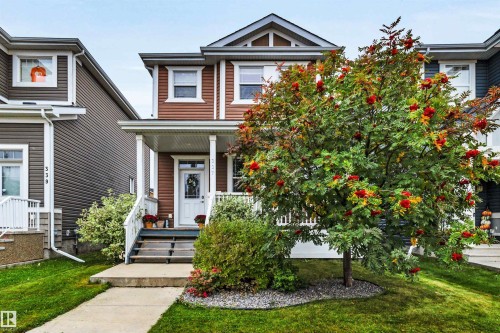 Two-story home with brown siding, white trim, and a covered front porch - 337 Southfork Drive, Leduc, AB 