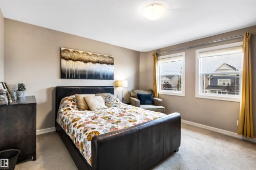 Neutral wall paint, ceiling-mounted light fixture, two windows, window blinds, and carpeting - 337 Southfork Drive, Leduc, AB 
