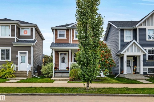 Two-story residential structure featuring a covered front porch, white trim accents, and a paved walkway - 337 Southfork Drive, Leduc, AB 