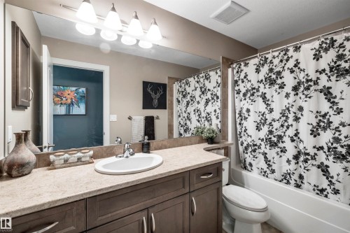 Extended vanity with an integrated sink, stone-finish countertop, and dark wood-finish cabinetry - 337 Southfork Drive, Leduc, AB 