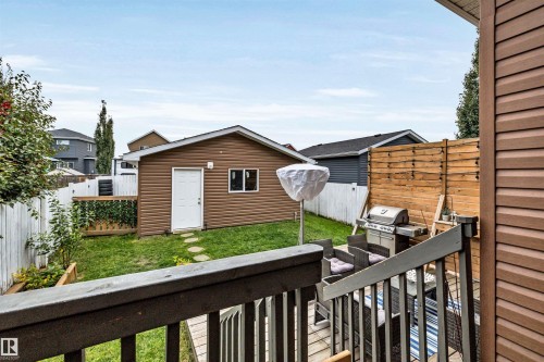 Expansive backyard featuring a detached garage, a wooden privacy screen, and a white picket fence - 337 Southfork Drive, Leduc, AB 