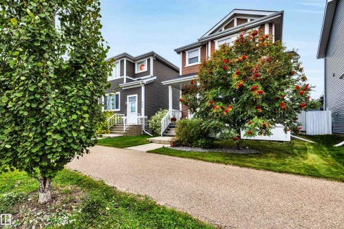Attached property featuring a gravel driveway, mature front yard trees, and a manicured lawn - 337 Southfork Drive, Leduc, AB 