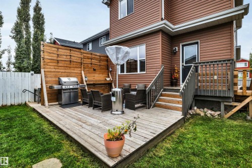 Expansive wood-finish deck with built-in privacy screen, complementing the home's brown siding, with a direct exterior entry - 337 Southfork Drive, Leduc, AB 