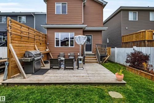 Spacious wood deck with direct entry, privacy screen, and a green lawn area - 337 Southfork Drive, Leduc, AB 