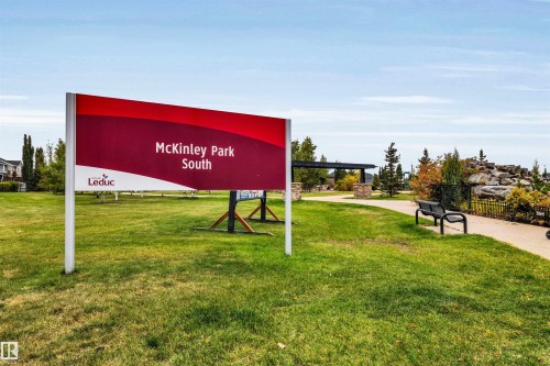 Expansive green space featuring a paved walkway, park bench, and a modern pergola - 337 Southfork Drive, Leduc, AB 