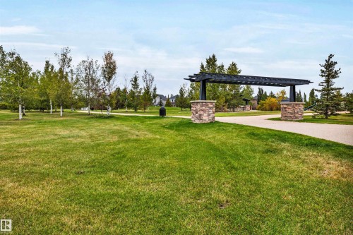 Expansive grassy area with mature trees and a paved pathway - 337 Southfork Drive, Leduc, AB 