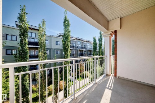 Private balcony with concrete flooring, white metal railings, and a fluted column with brick detailing - #307 1003 Gault Bv Nw, Edmonton, AB 