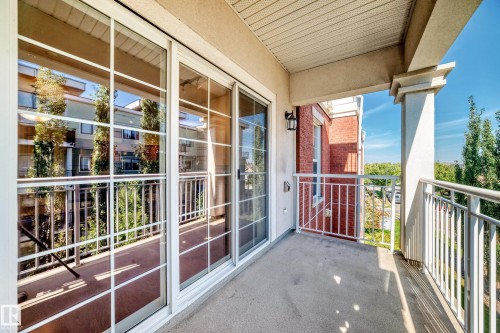Outdoor balcony featuring concrete flooring, white metal railings, and a prominent column - #307 1003 Gault Bv Nw, Edmonton, AB 